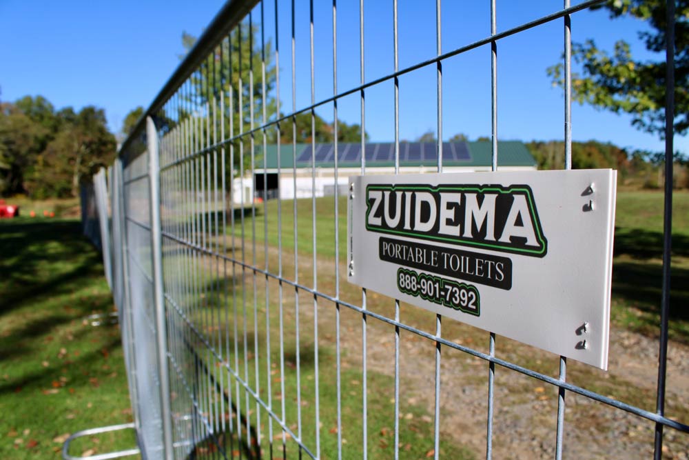 Board of Zuidema Portable Toilets on Temporary Fence in New York & New Jersey